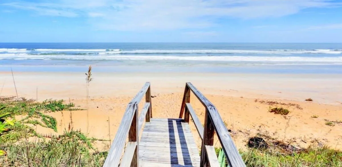 Wooden beach walkover crossing the sea oats and dunes onto the wide sand and surf at Flagler Beach