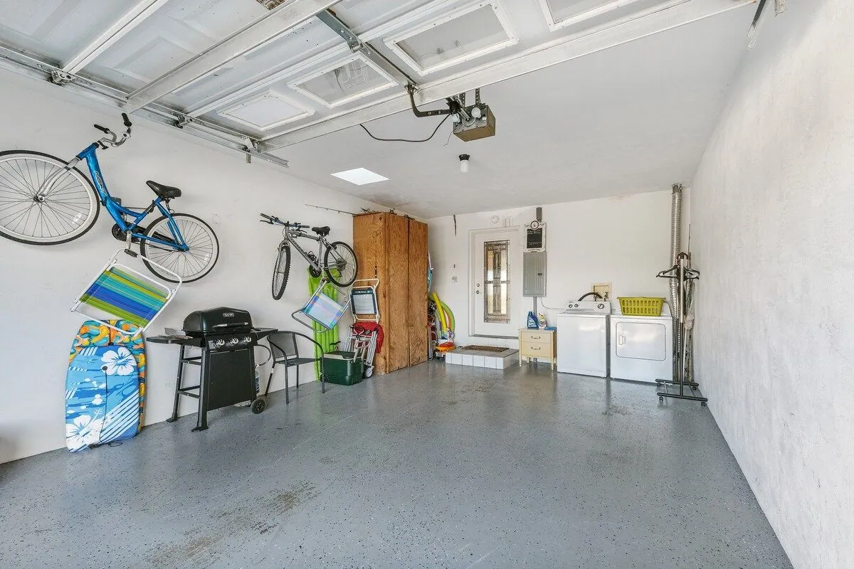 Private garage holding bikes, boogie boards, beach chairs and a barbecue grill, alongside the in-unit washer and dryer
